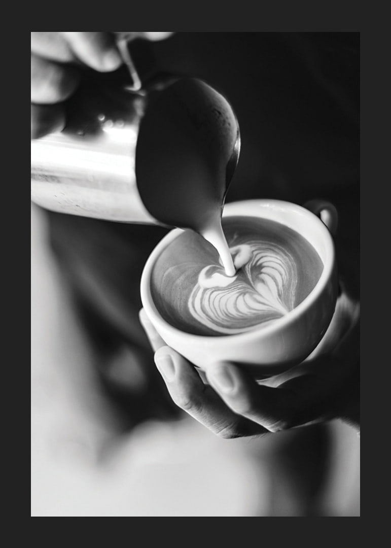 Svartvitt foto av barista som häller latteart i kopp-12