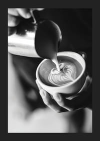 Čiernobiela fotografia baristu, ktorý nalieva latte art do šálky-5