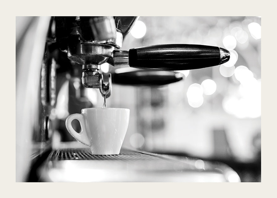 Black and white photo of espresso machine with cup during brewing-12