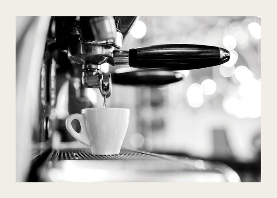 Fotografie alb-negru a unui espressor cu ceașcă în timpul preparării-12