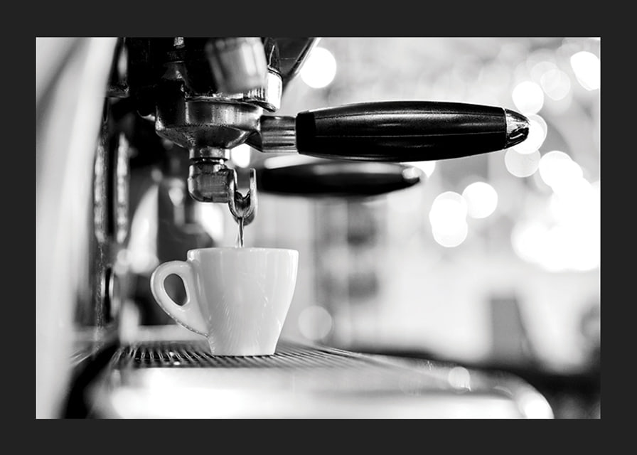 Black and white photo of espresso machine with cup during brewing-12