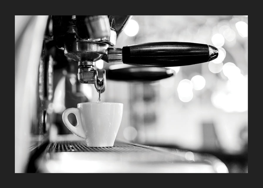 Fotografie alb-negru a unui espressor cu ceașcă în timpul preparării-12