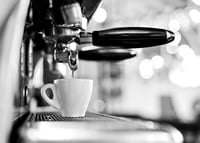 Black and white photo of espresso machine with cup during brewing-7