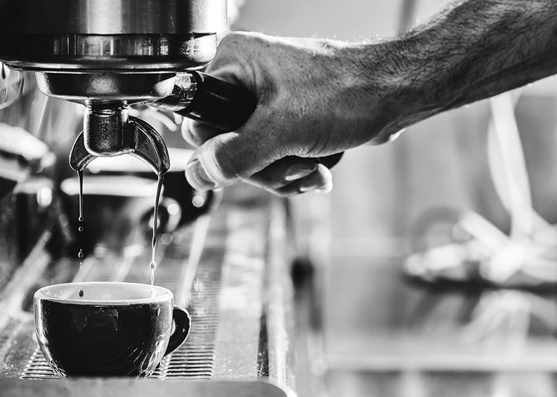 Black and white photo of hand brewing espresso in cup-12
