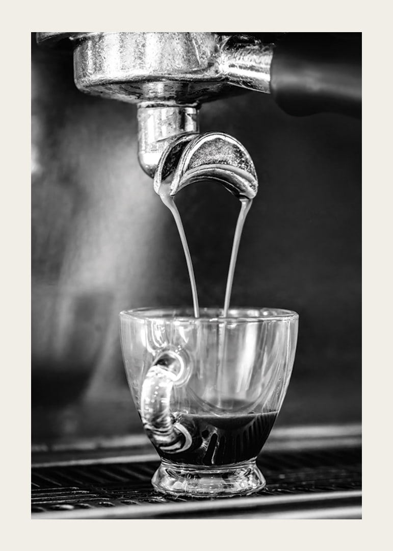 Black and white photo of espresso machine brewing coffee in cup-12