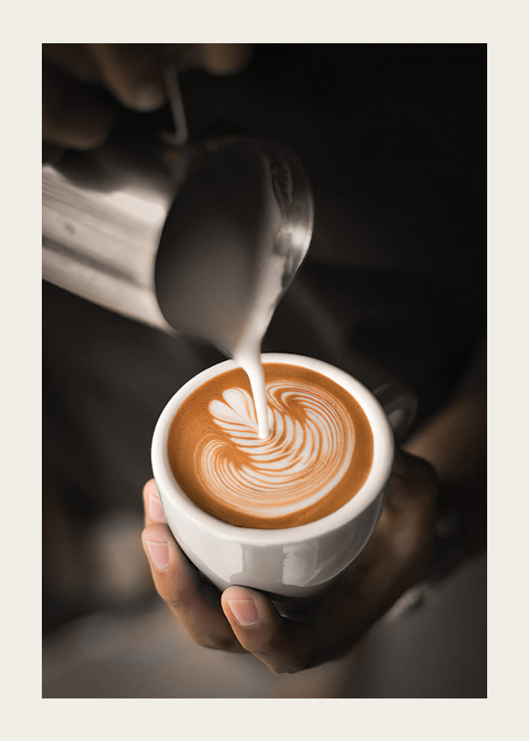 Detailný záber baristu, ako nalieva mlieko do caffè latte, fotografia-12