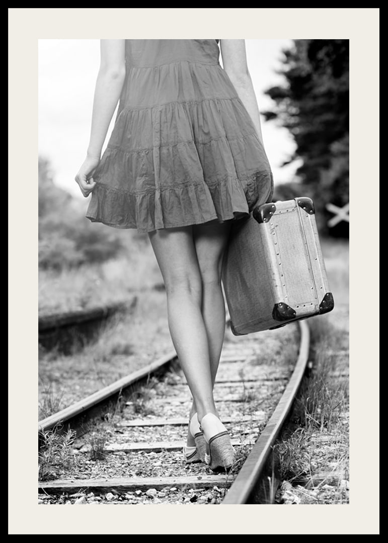 Black and white photograph of girl with suitcase on railway tracks-12