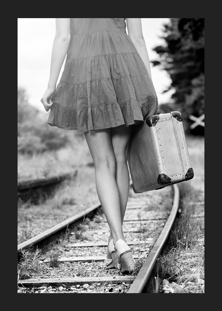 Zwart-witfoto van meisje met koffer op spoorrails-12