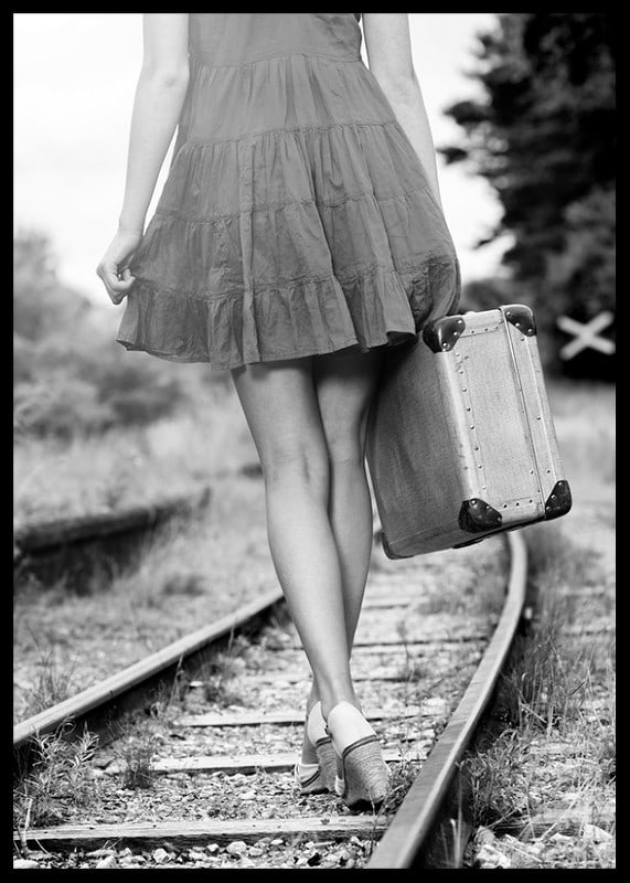 Black and white photograph of girl with suitcase on railway tracks-12