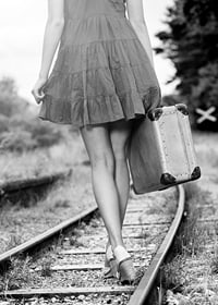 Black and white photograph of girl with suitcase on railway tracks-7