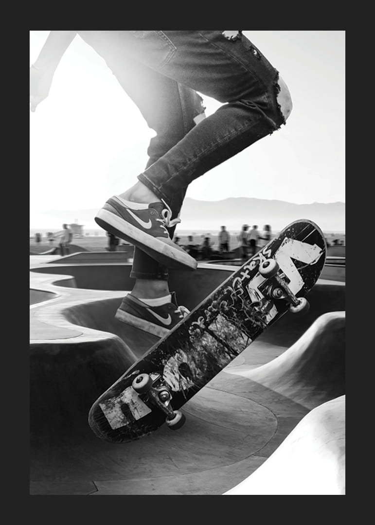 Fekete-fehér közeli felvétel gördeszkázási trükkökről a szabadtéri gördeszkaparkban-12