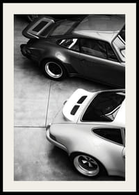 Svartvitt foto av två klassiska Porsche 911 ovanifrån-2