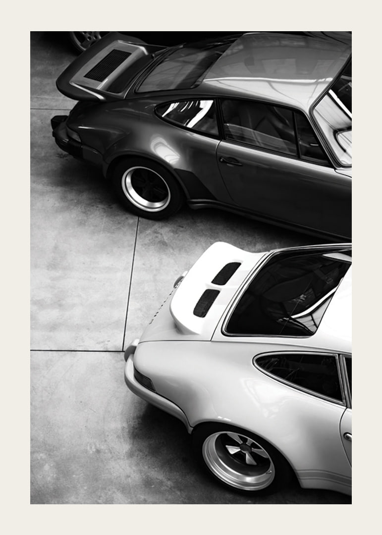 Svartvitt foto av två klassiska Porsche 911 ovanifrån-12