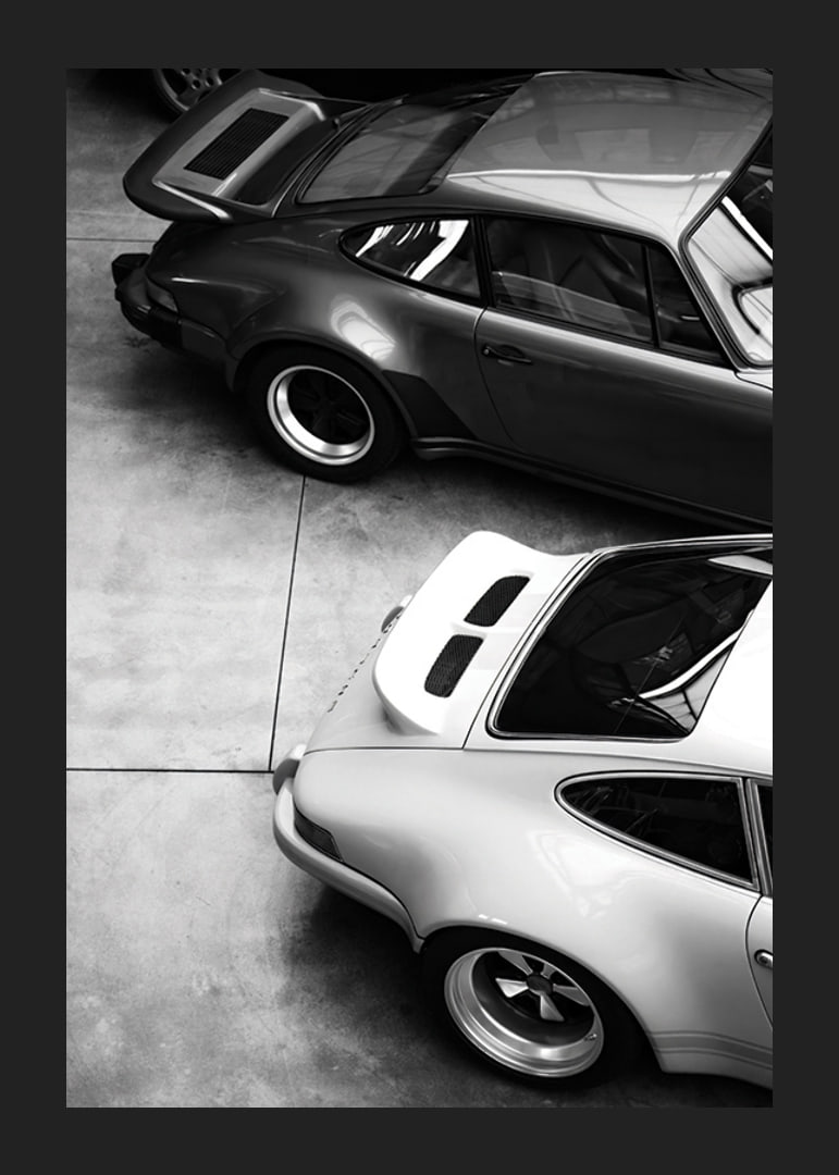 Svartvitt foto av två klassiska Porsche 911 ovanifrån-12