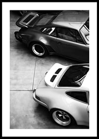 Svartvitt foto av två klassiska Porsche 911 ovanifrån-0