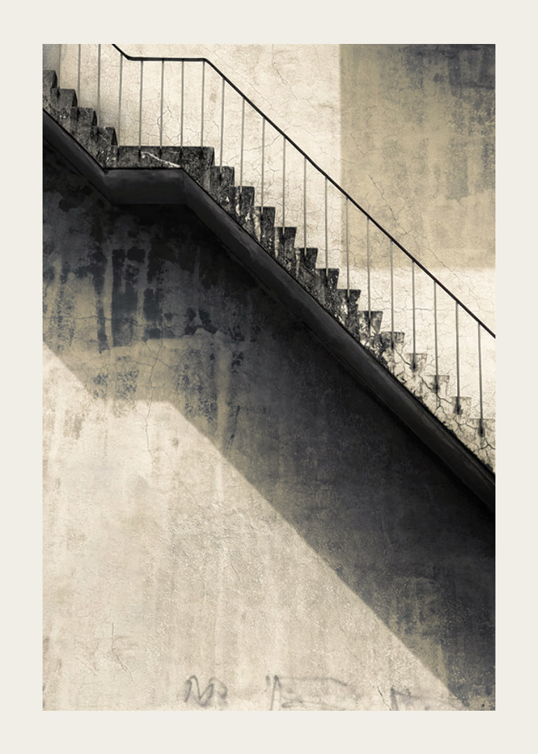 Fotografia de escada de concreto com corrimão contra parede desgastada-12