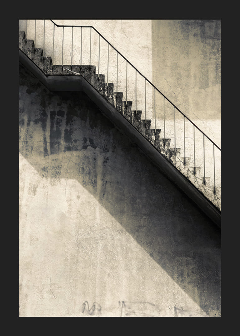 Foto van een betonnen trap met leuning tegen een versleten muur-12