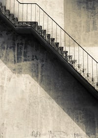 Fotografia de escada de concreto com corrimão contra parede desgastada-7