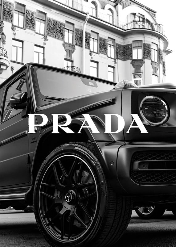 Black and white close-up of Mercedes G-Class in front of building with Prada text-12