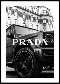 Black and white close-up of Mercedes G-Class in front of building with Prada text-0