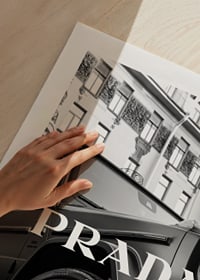 Black and white close-up of Mercedes G-Class in front of building with Prada text-9