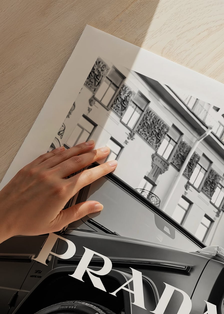 Black and white close-up of Mercedes G-Class in front of building with Prada text-12