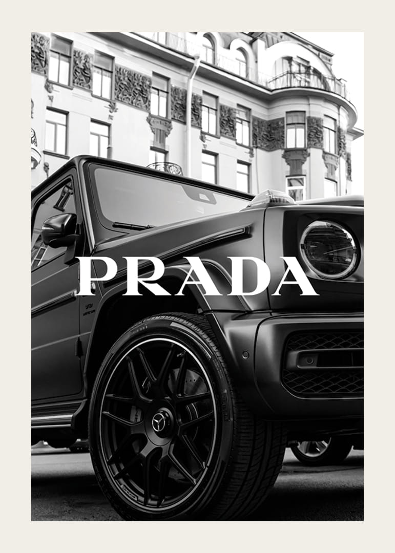 Black and white close-up of Mercedes G-Class in front of building with Prada text-12