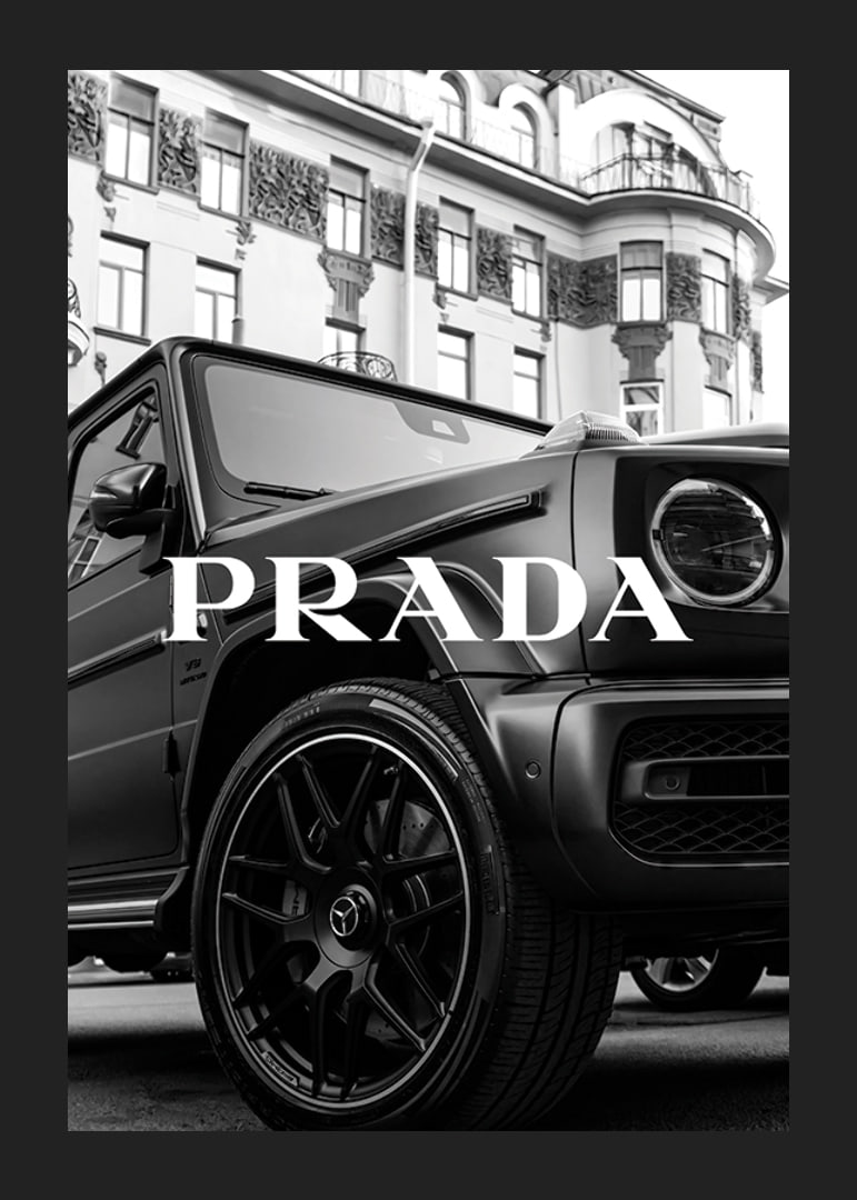 Black and white close-up of Mercedes G-Class in front of building with Prada text-12