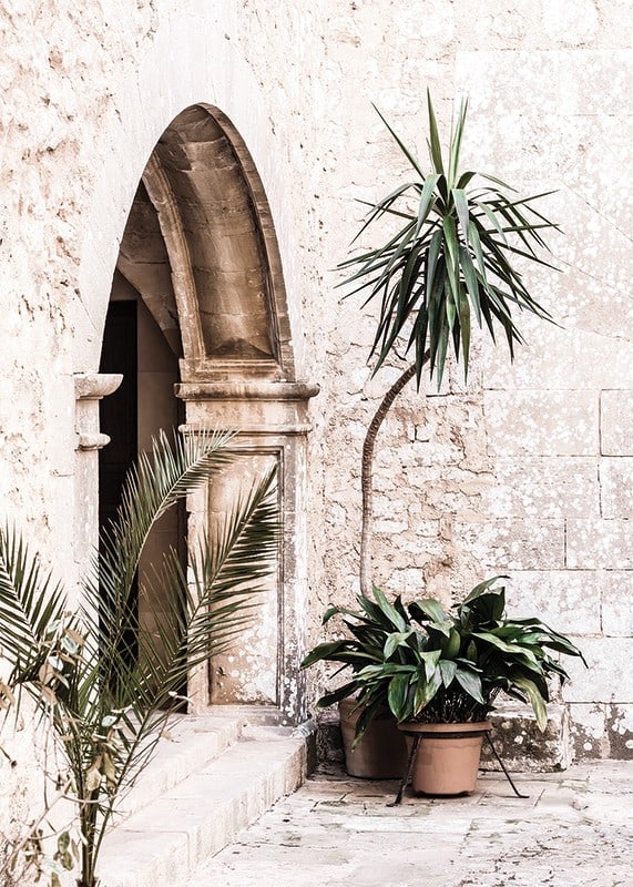 Photograph of stone arches and potted plants in a bright Mediterranean setting-12