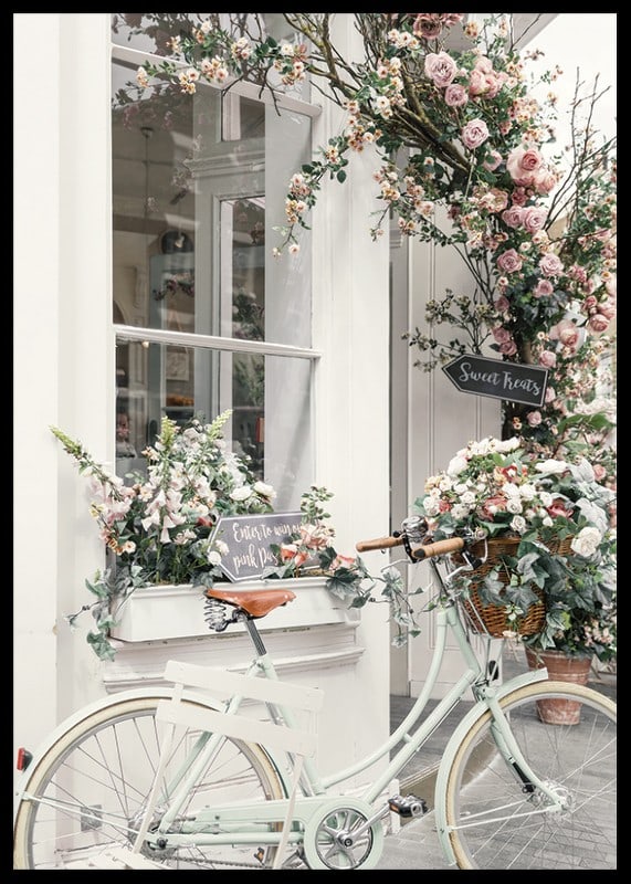 Photograph of white bicycle with flower basket in front of flower-adorned facade-12