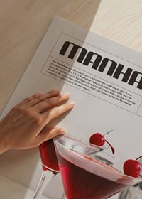 Två Manhattan-cocktails med körsbär, barredskap och recepttext-3