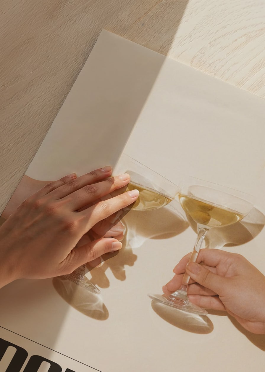 Twee handen houden martiniglazen met olijven vast tegen een beige achtergrond-12