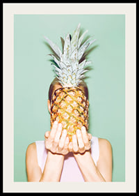 Fotografi av kvinna som håller en ananas framför ansiktet mot ljusgrön bakgrund-2
