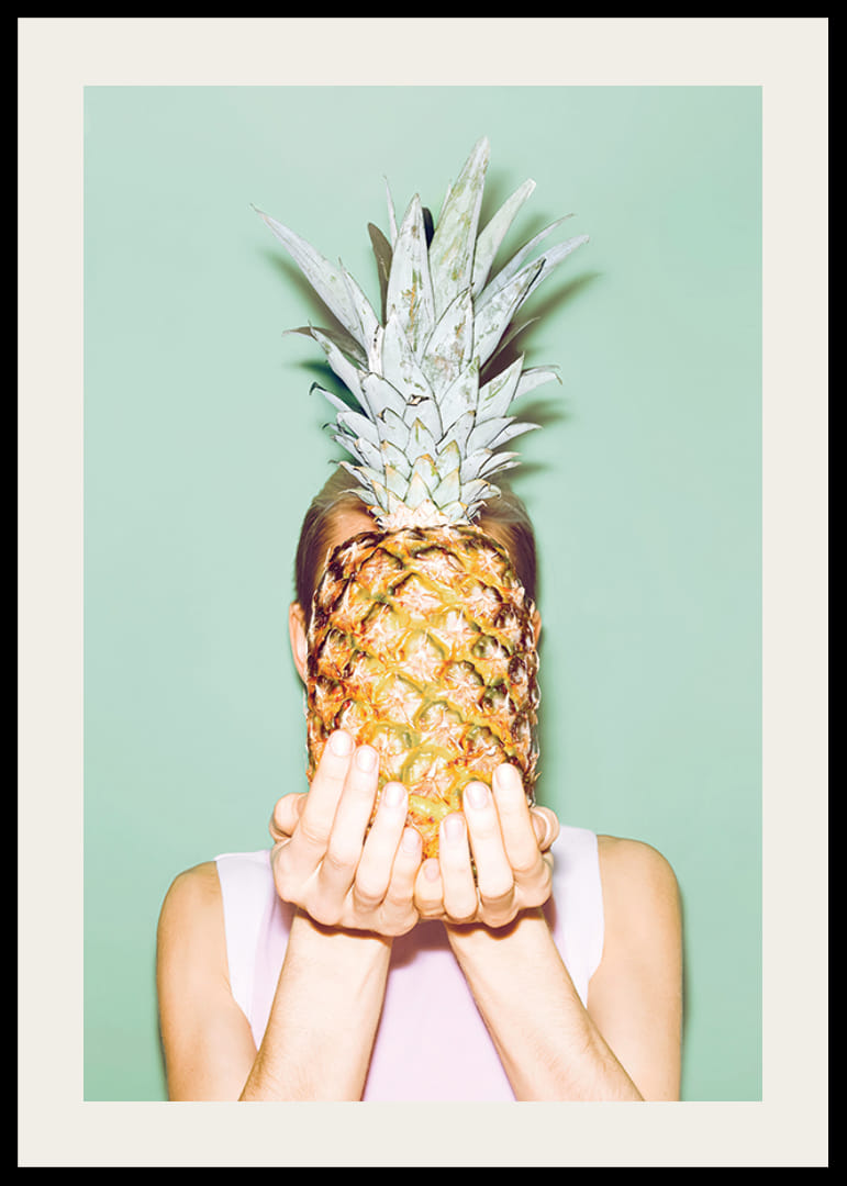 Foto einer Frau, die vor einem hellgrünen Hintergrund eine Ananas vor ihr Gesicht hält-12