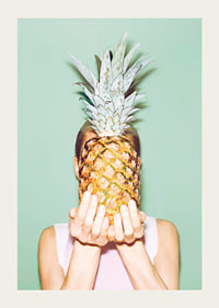 Fotografi av kvinna som håller en ananas framför ansiktet mot ljusgrön bakgrund-3
