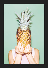 Fotografi av kvinna som håller en ananas framför ansiktet mot ljusgrön bakgrund-5