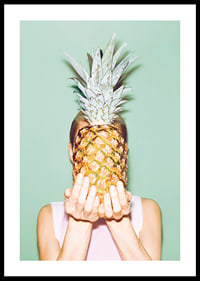 Fotografi av kvinna som håller en ananas framför ansiktet mot ljusgrön bakgrund-0
