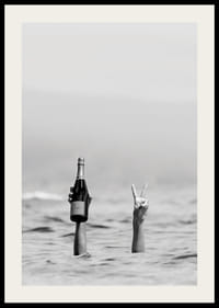 Svartvitt fotografi med två armar i vatten, en håller champagne-2