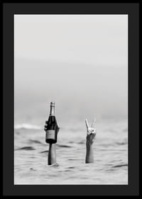 Svartvitt fotografi med två armar i vatten, en håller champagne-4