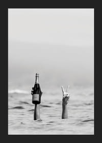Svartvitt fotografi med två armar i vatten, en håller champagne-5