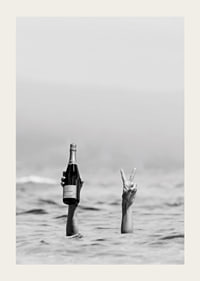 Fotografia in bianco e nero di due braccia nell'acqua, una delle quali tiene in mano dello champagne-3