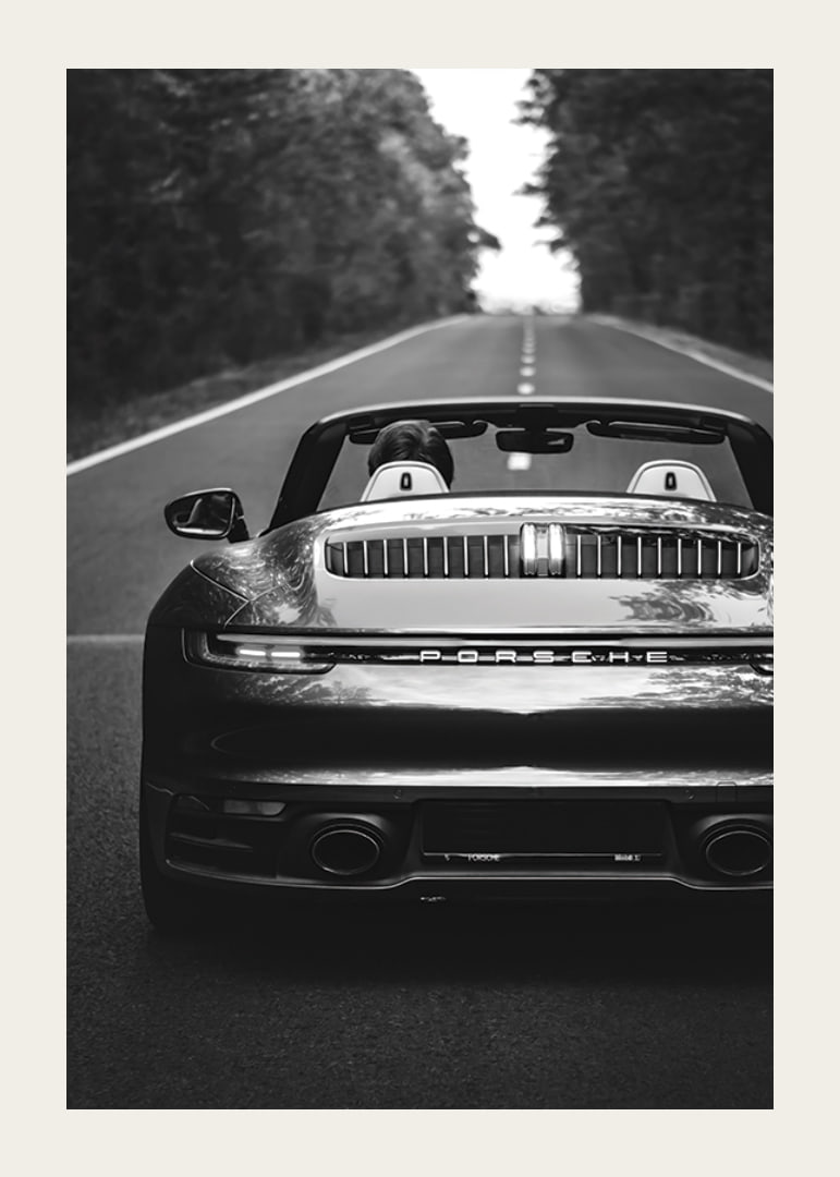 Black and white Porsche 911 convertible rear view on country road-12