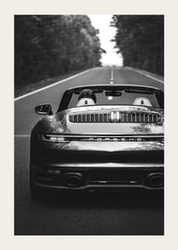 Black and white Porsche 911 convertible rear view on country road-3