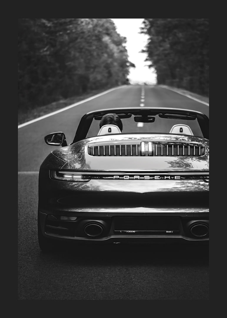 Black and white Porsche 911 convertible rear view on country road-12
