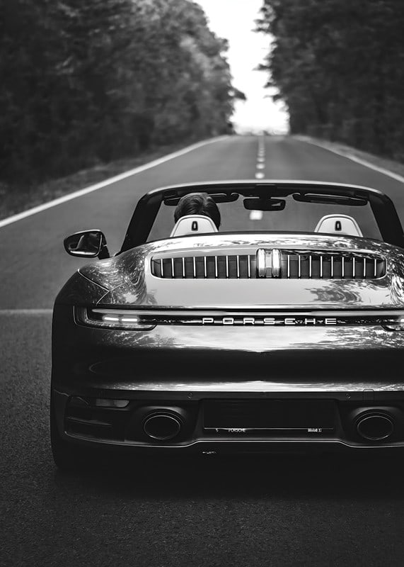 Black and white Porsche 911 convertible rear view on country road-12
