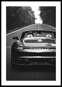 Black and white Porsche 911 convertible rear view on country road-0