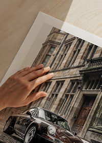 Classic black Porsche 911 in front of historic stone facade-9