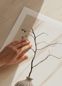 Fotografie eines Zweiges in einer Keramikvase vor hellem Hintergrund-9