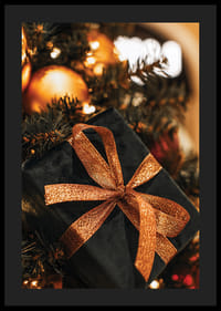 Lähikuva mustasta joululahjasta kimaltelevalla nauhalla kuusen oksien välissä-4