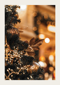 Primo piano di un abete con decorazioni dorate e luci calde-3